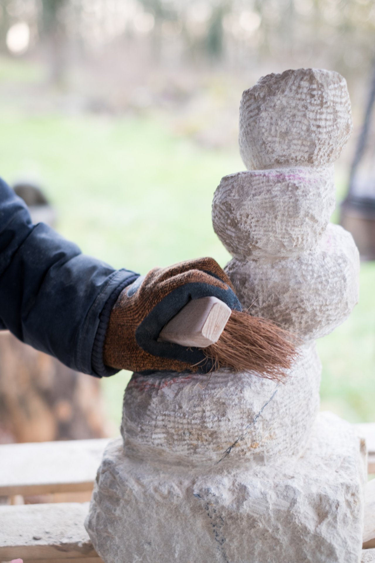 Eindr&uuml;cke der Seminararbeit: Eine selbst gemei&szlig;elte Skultur aus Stein wird mit einer Wurzelb&uuml;rste gereinigt. Die Skulptur sieht aus wie ein aus einzelnen, unterschiedlich gro&szlig;en Kugeln bestehender Turm, der leicht schief ist.